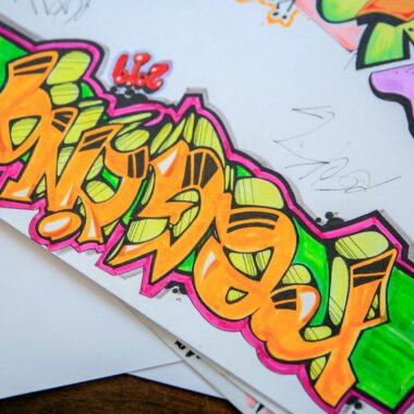 Colorful street art graffiti drawn on paper with vibrant colors and bold designs.