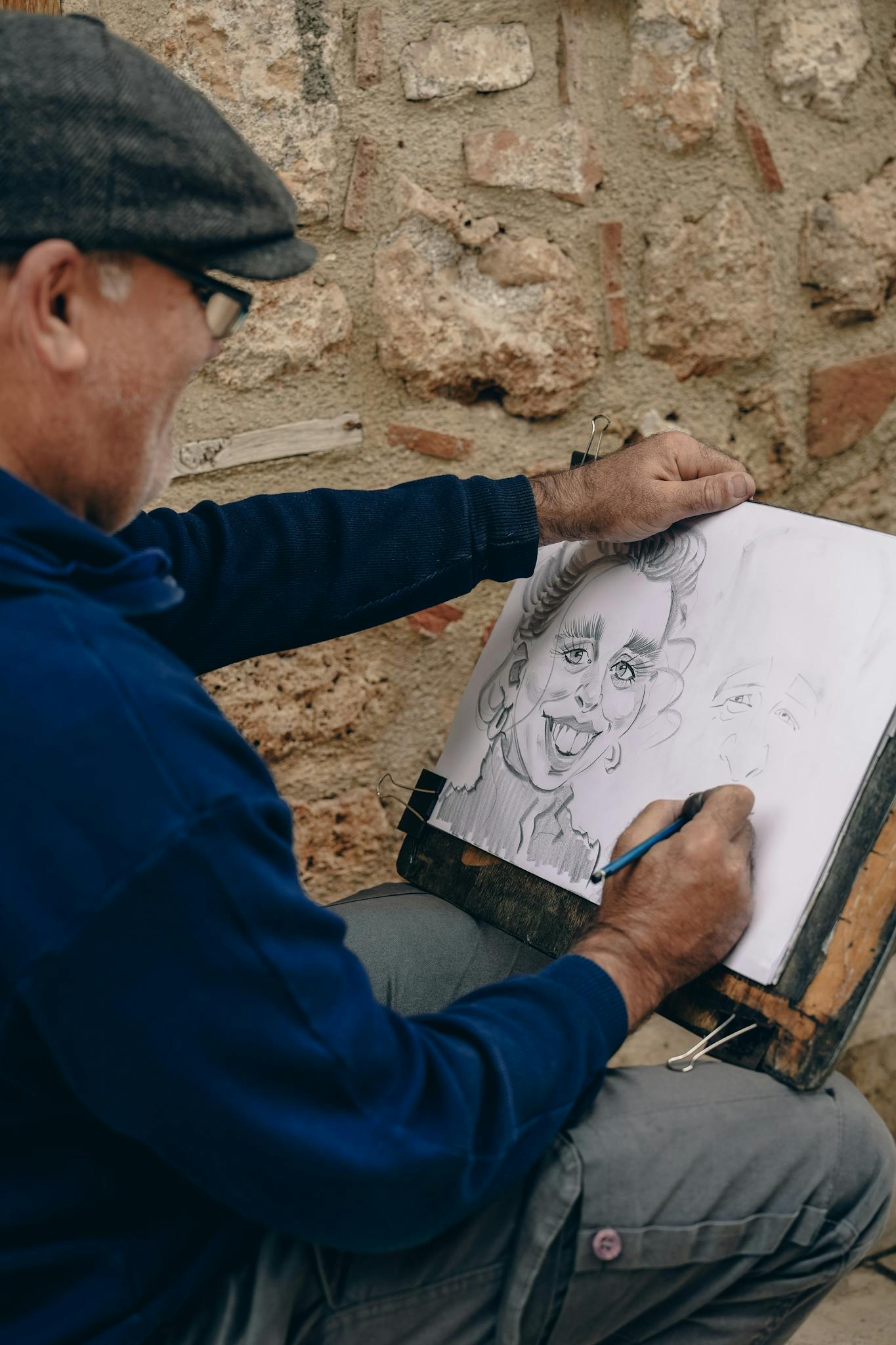Street artist draws a whimsical charcoal portrait of a man outdoors.